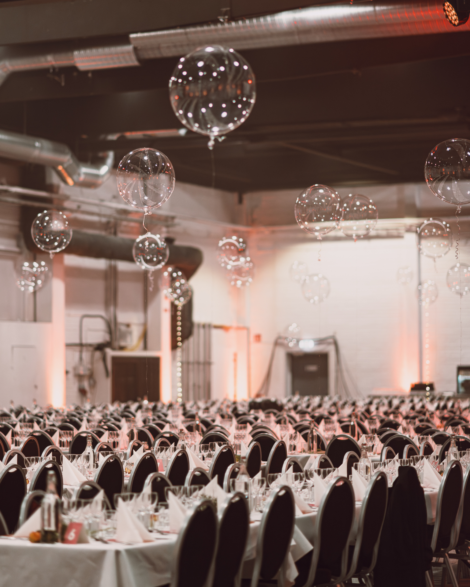 Stor festlokal med dukade bord och dekorativa ballonger