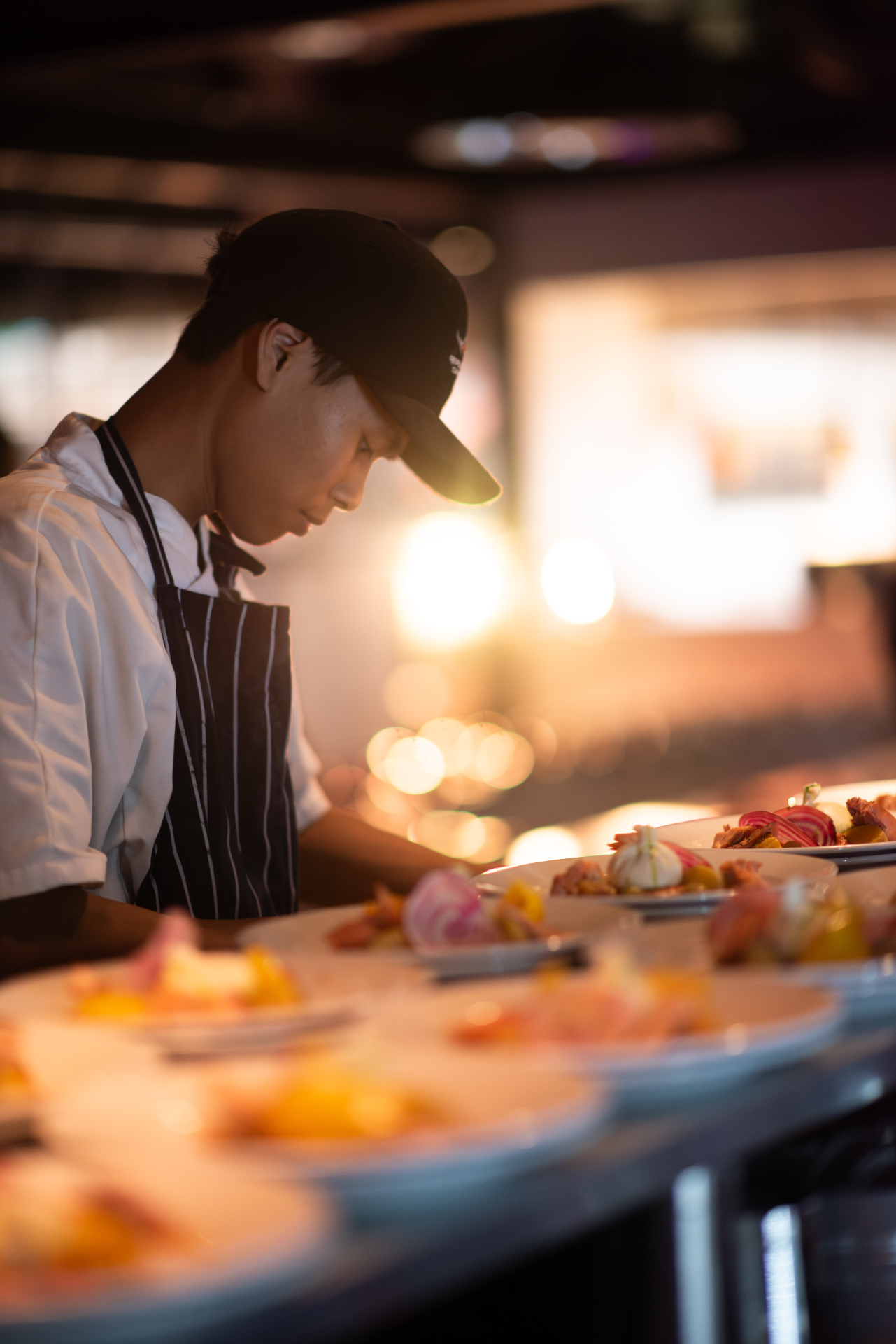Kock i förkläde förbereder tallrikar